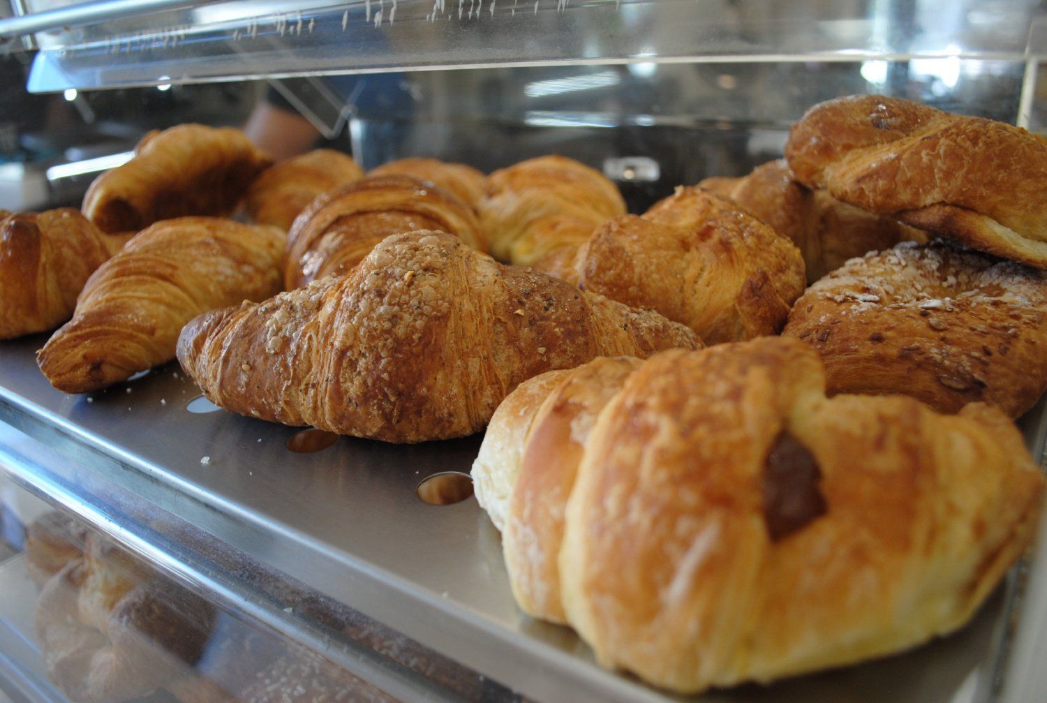 Un assortimento di croissant e pasticcini dorati disposti su un vassoio.