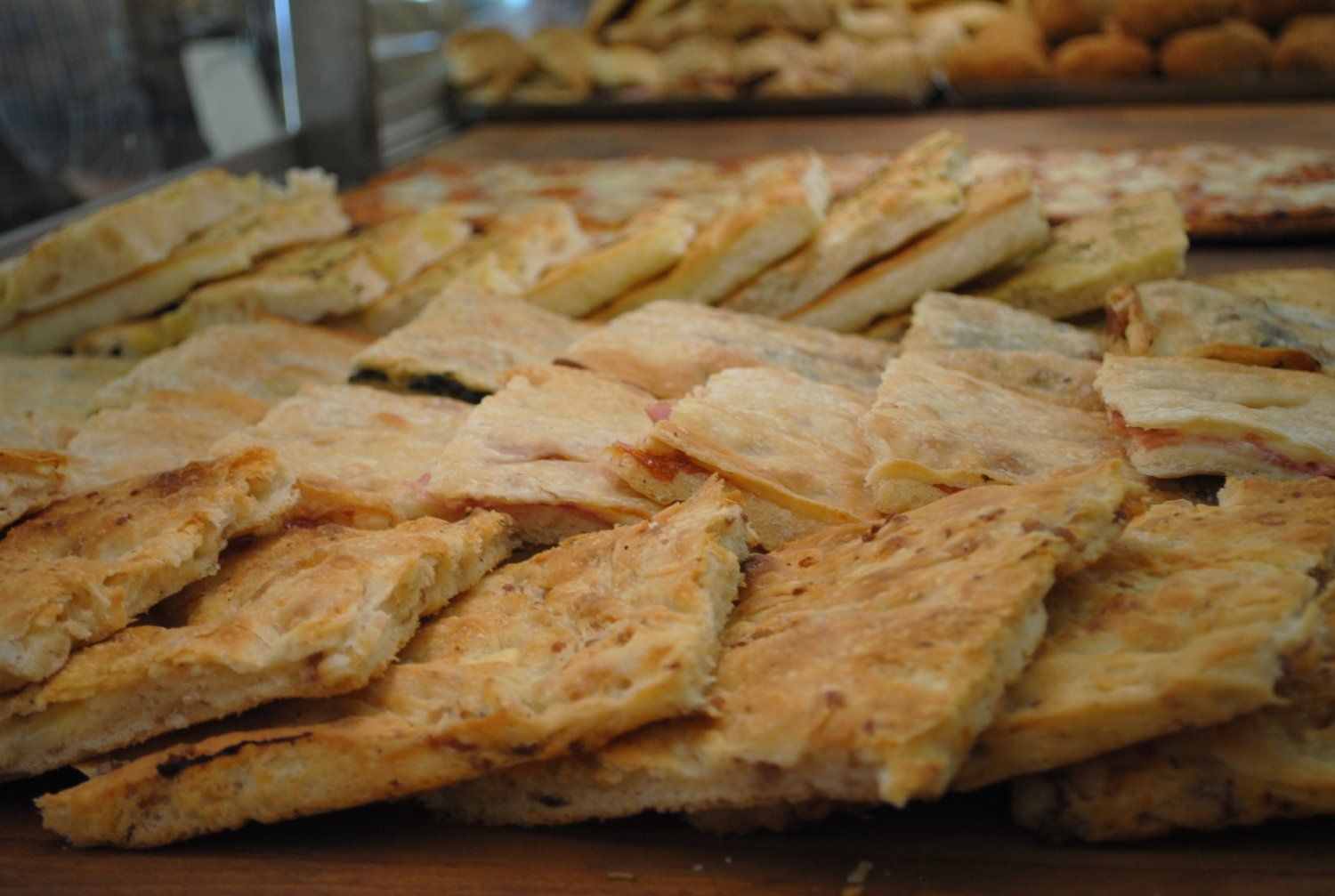 Vassoio di cracker dorati al forno, impilati in file su una superficie di legno.