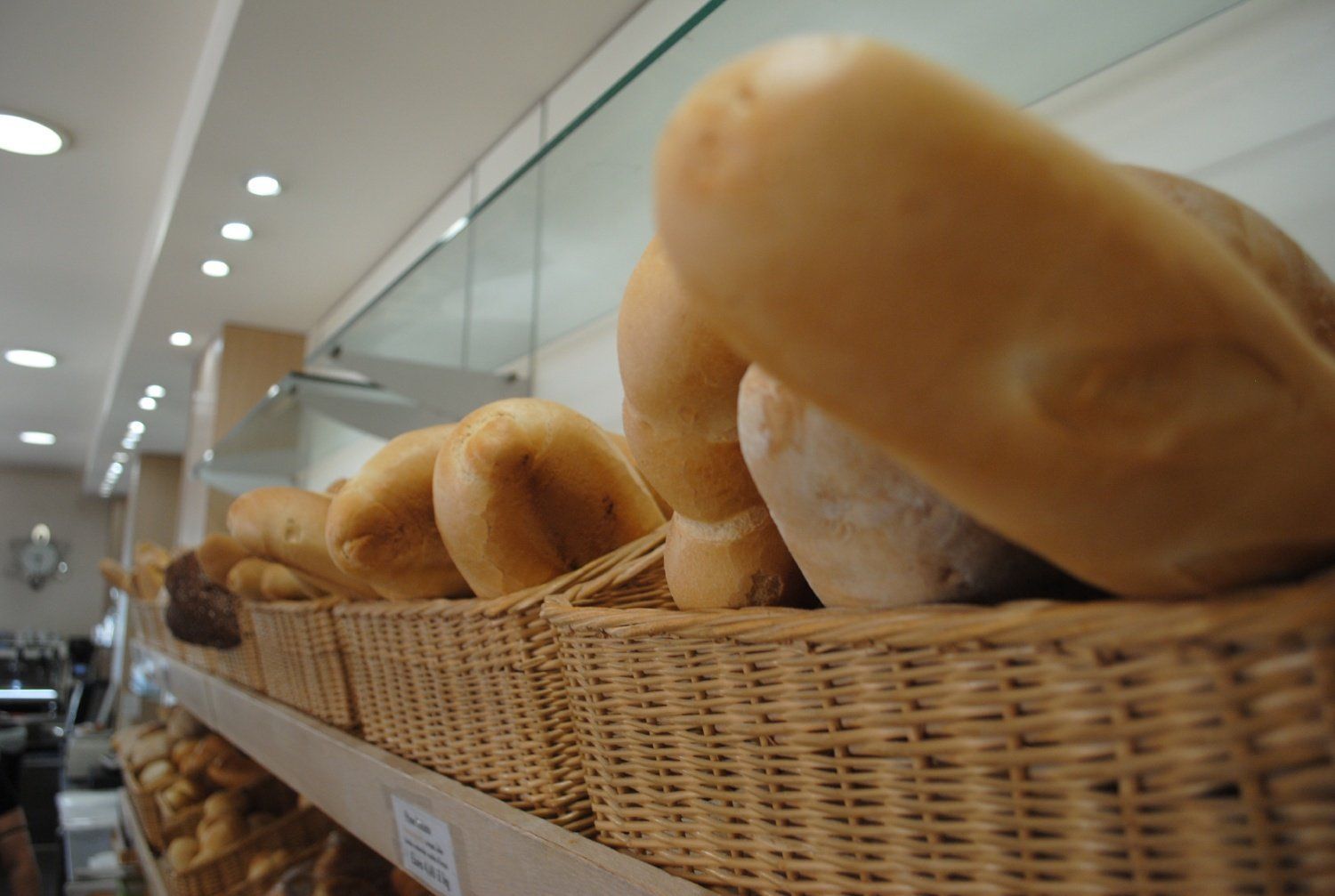 Pagnotte di pane in un cesto di vimini su uno scaffale di una panetteria.