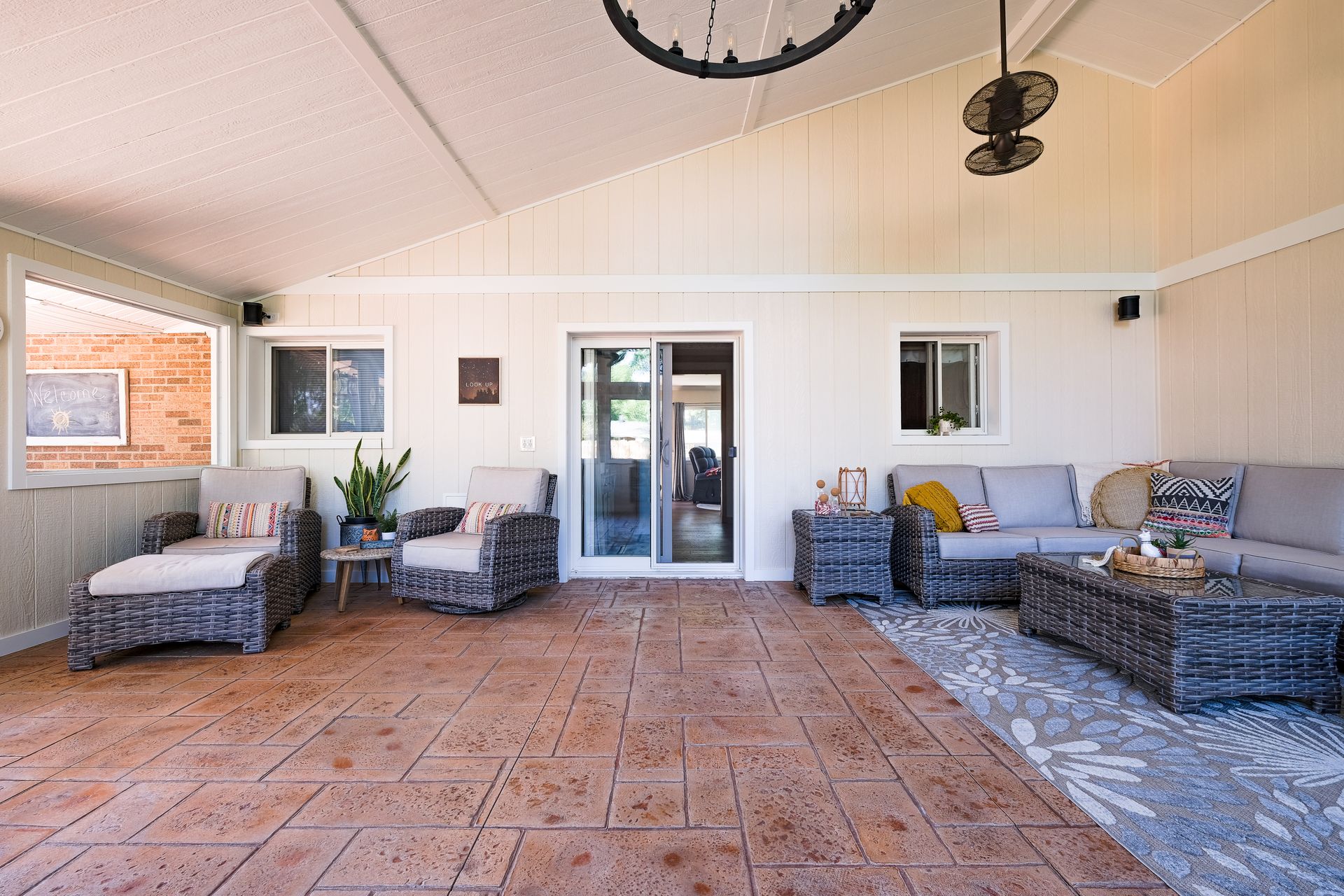 Covered patio with wicker furniture and stamped concrete floor.