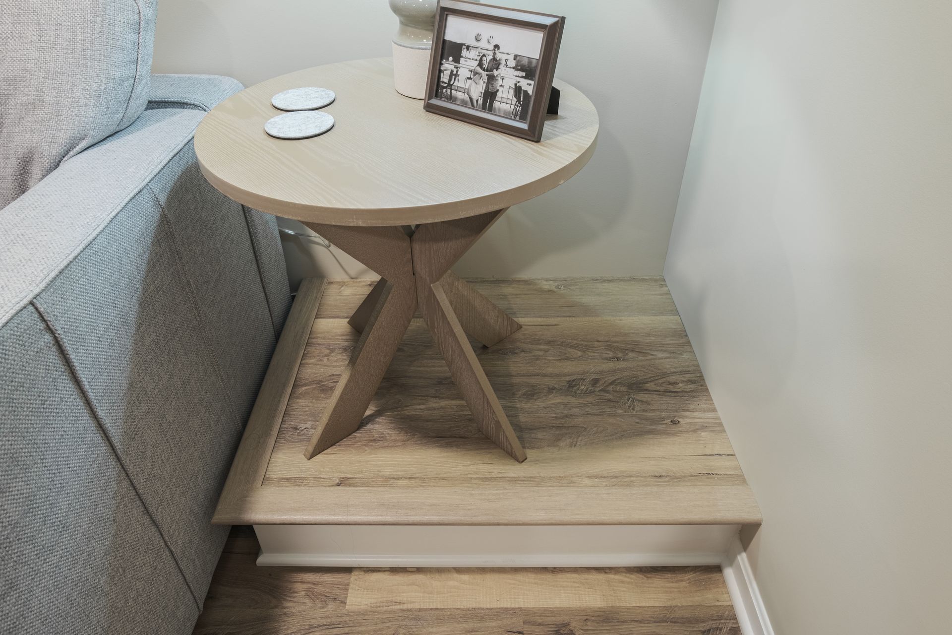 A round table with a picture frame on top of it in a living room.