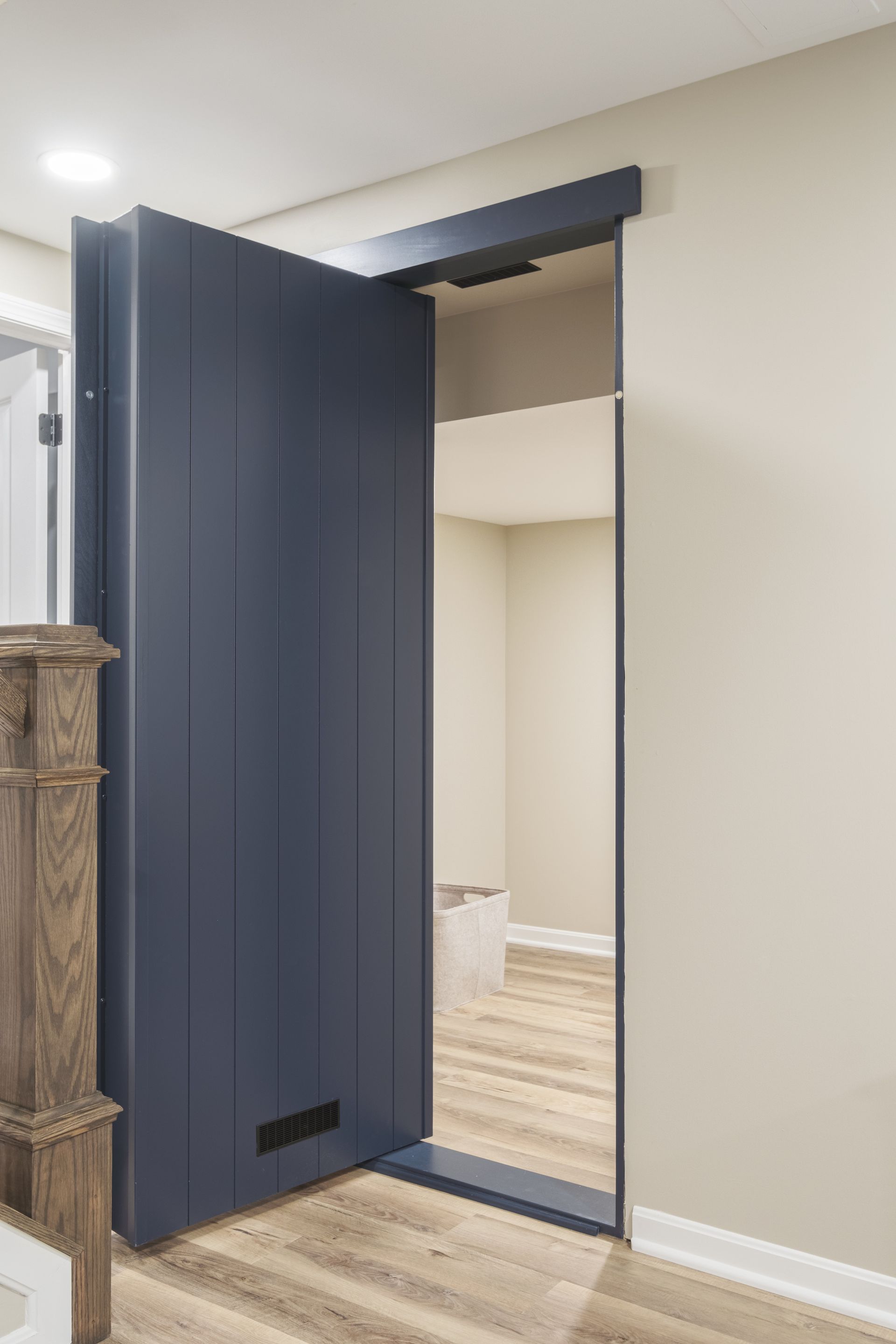 A blue door is open to a room with wooden floors.