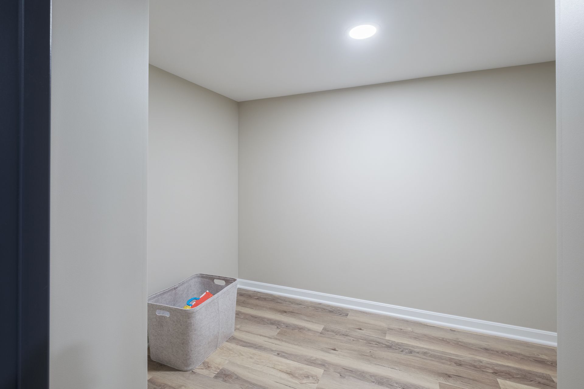 There is a basket of toys in the middle of the room.