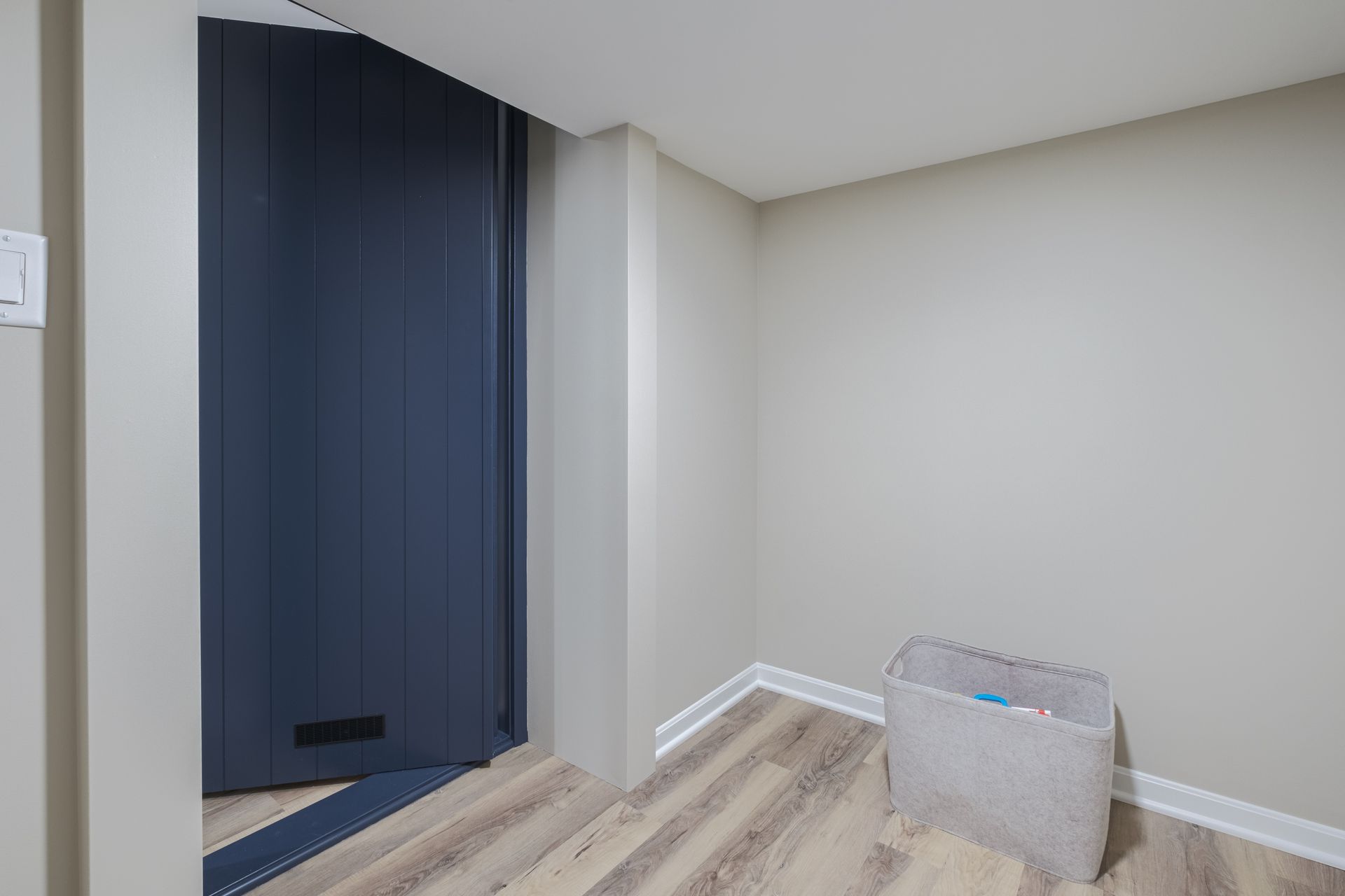 There is a laundry basket in the middle of the room.