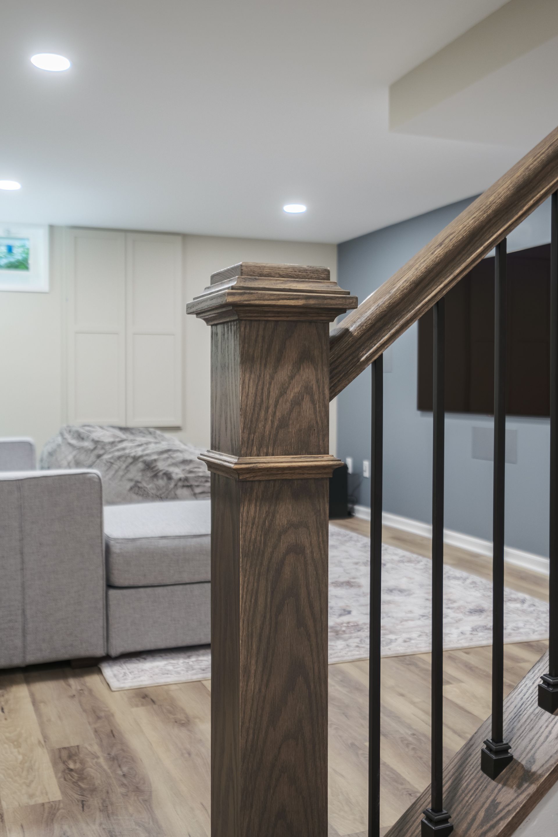 A living room with a couch and stairs leading up to the second floor.