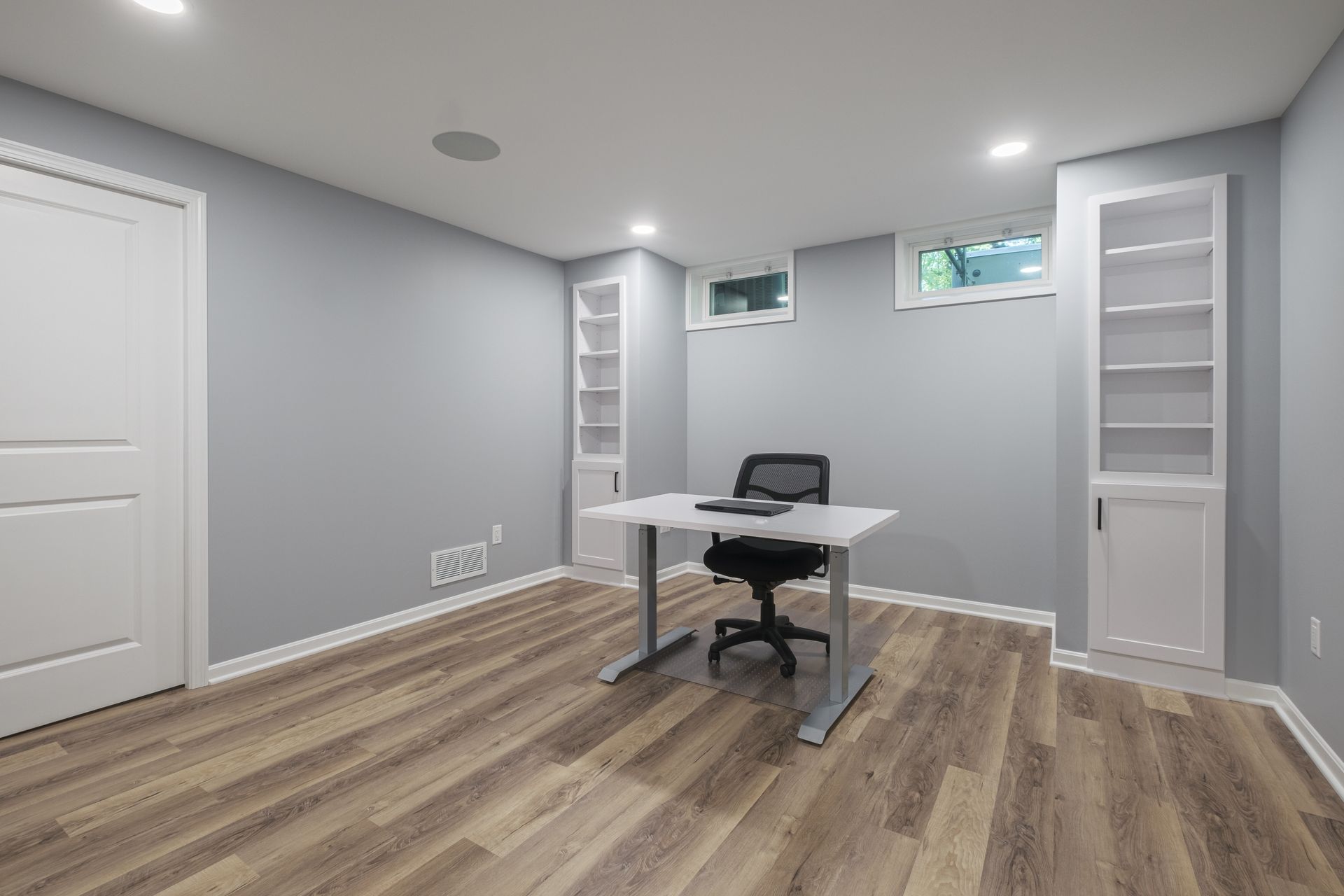 There is a desk and chair in the middle of the room.