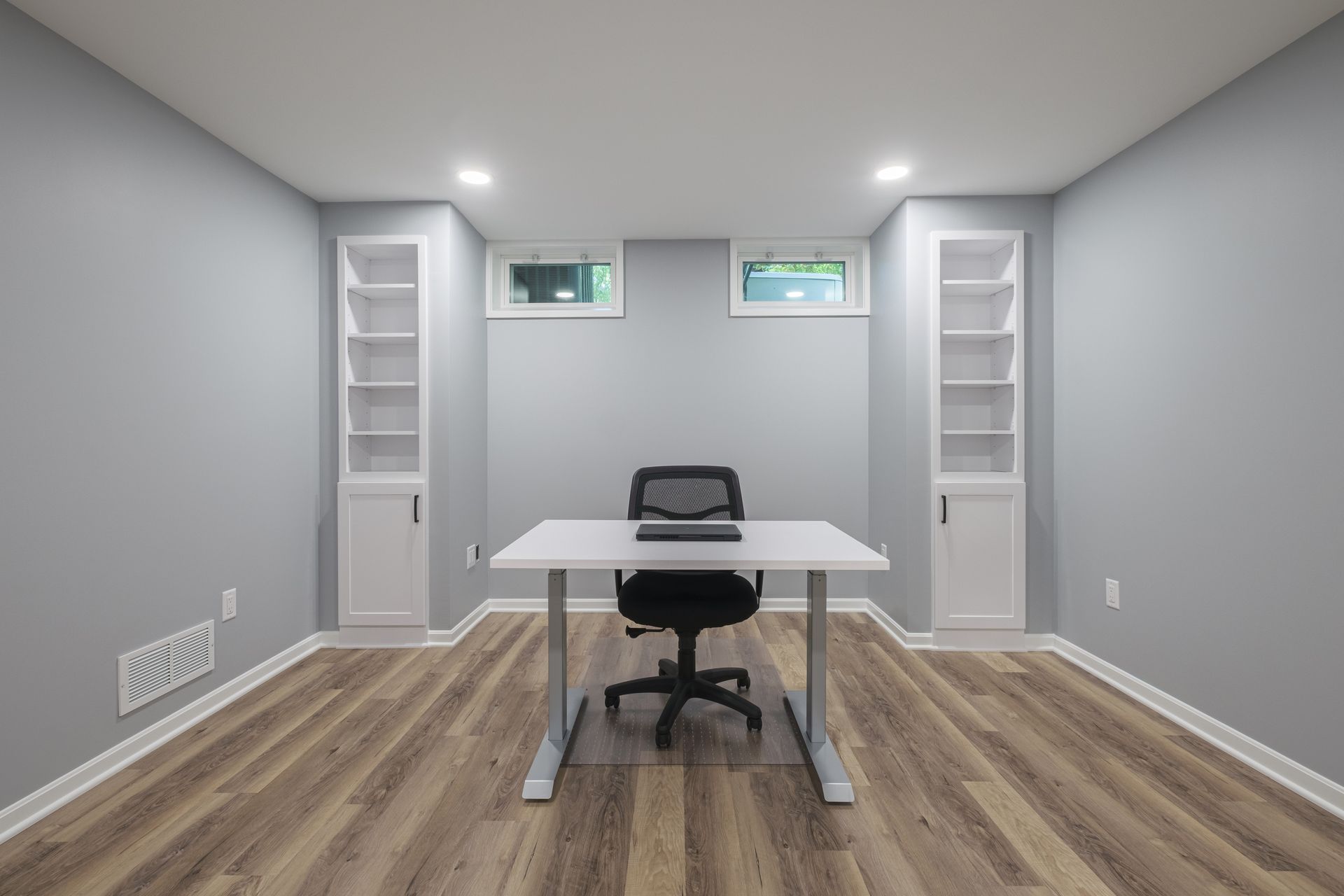 There is a desk and chair in the middle of the room.