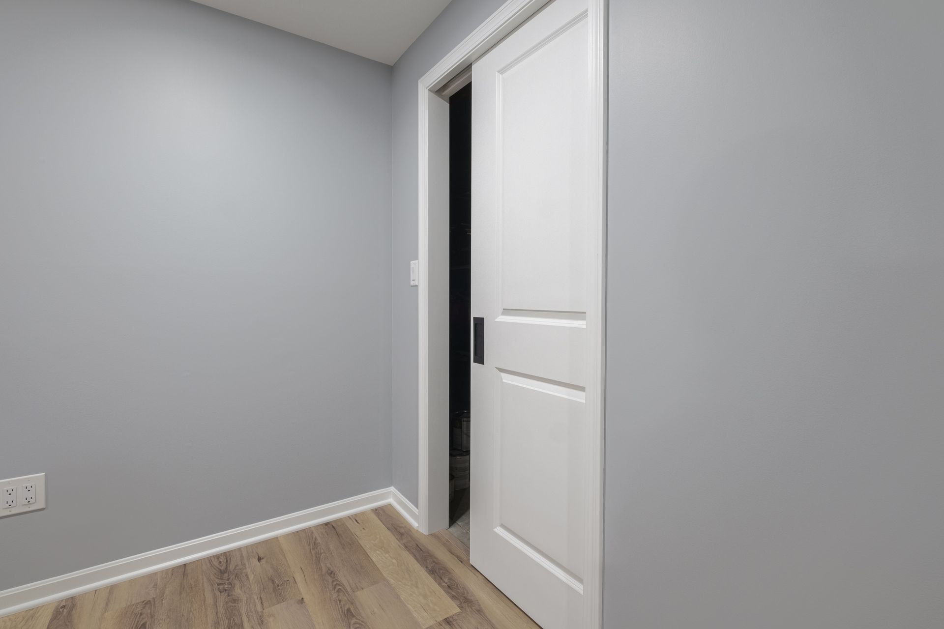 An empty room with a sliding door and a wooden floor.