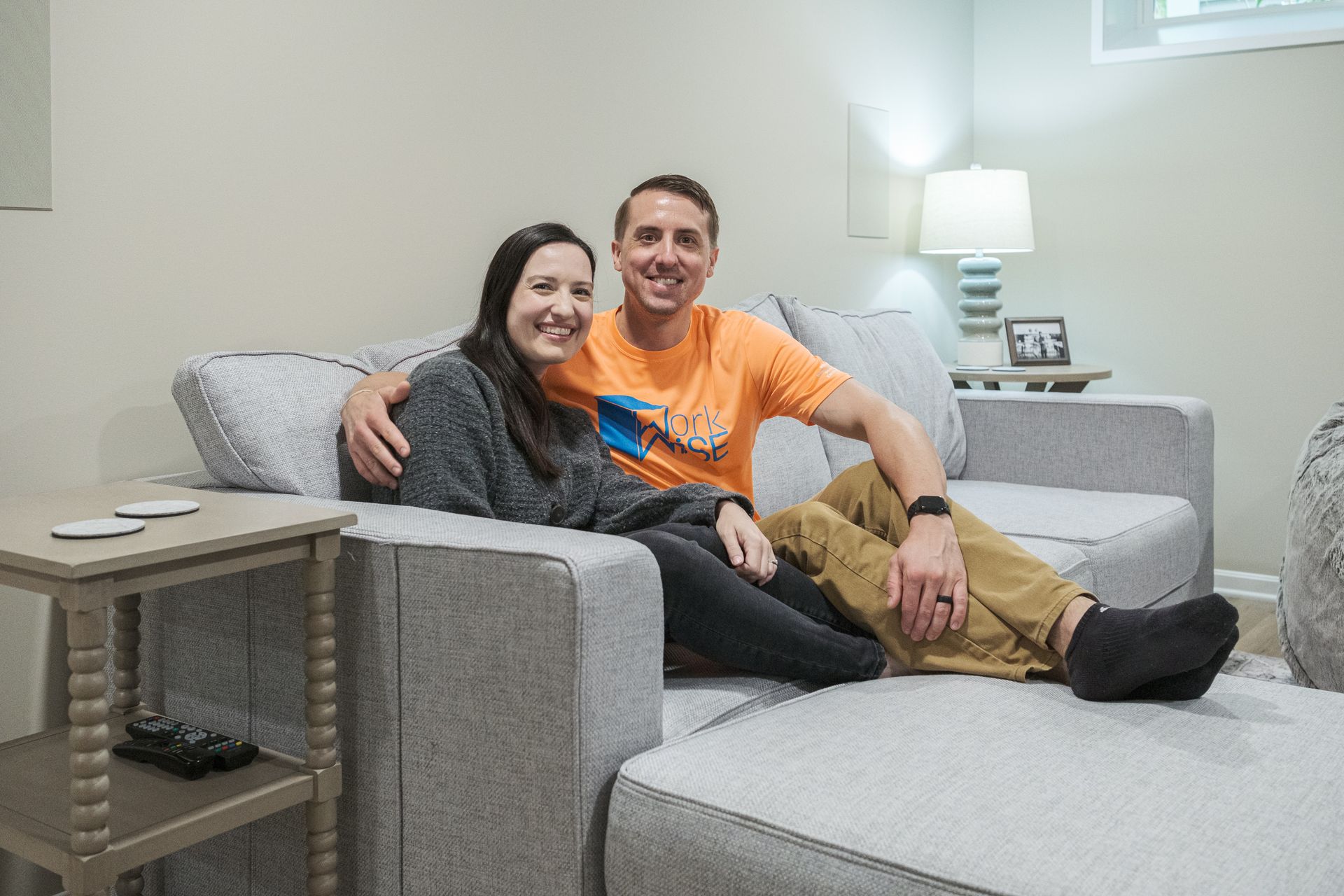 A man and a woman are sitting on a couch in a living room.