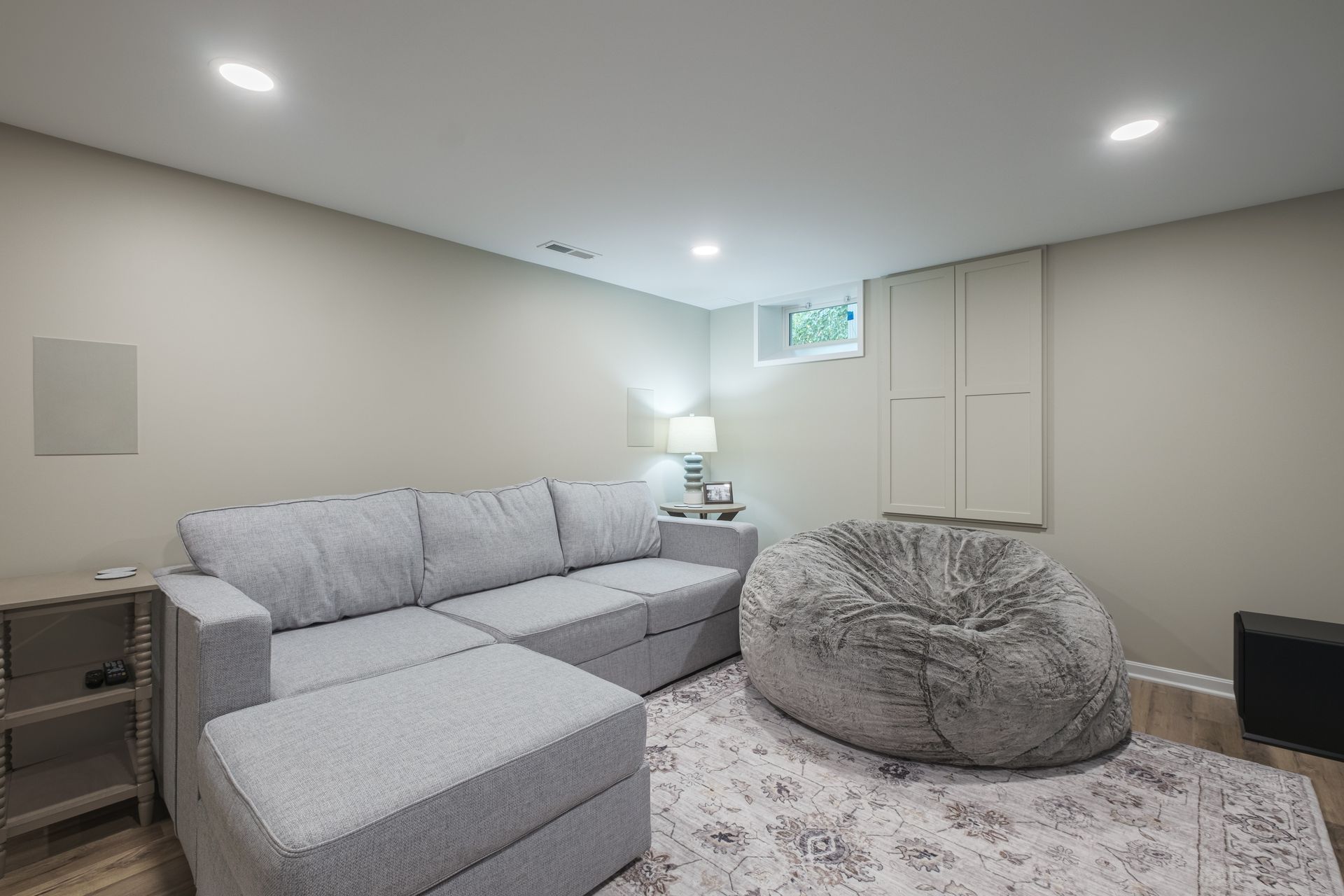 A living room with a couch and a bean bag chair.
