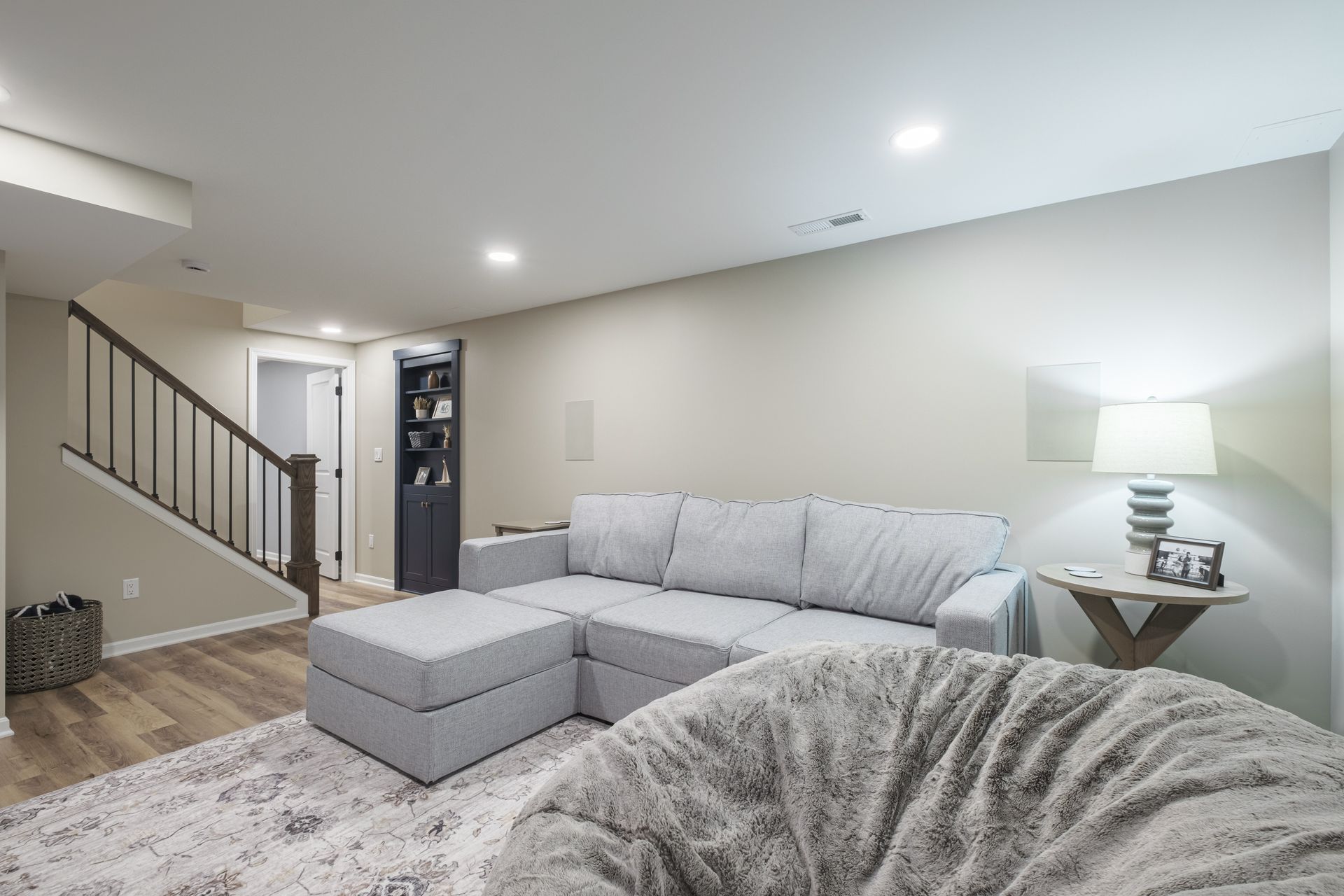 A living room with a couch , bean bag chair and stairs.