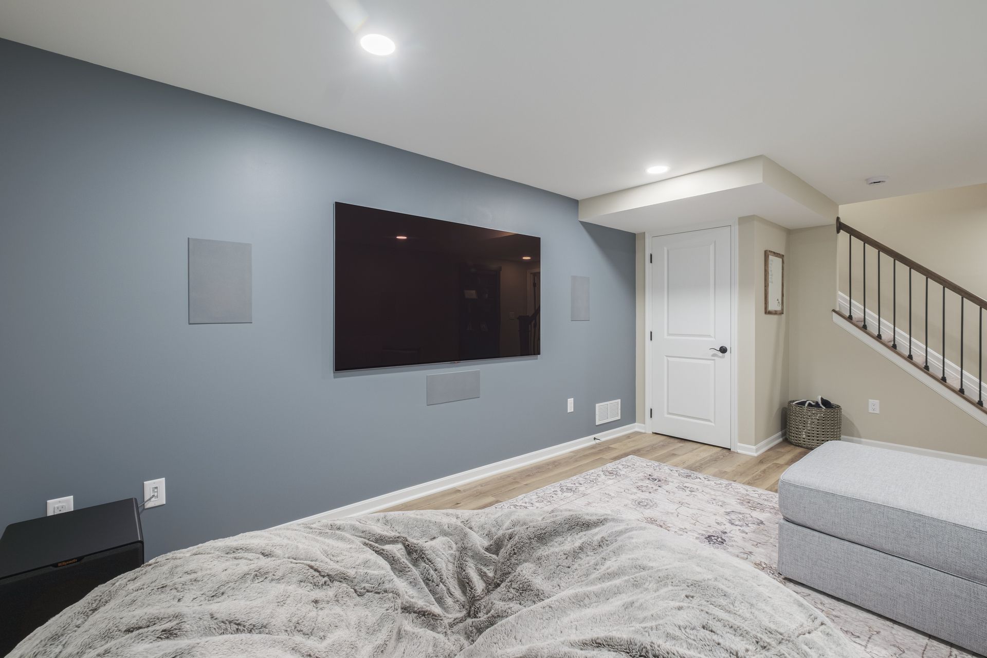 A living room with a large flat screen tv on the wall.