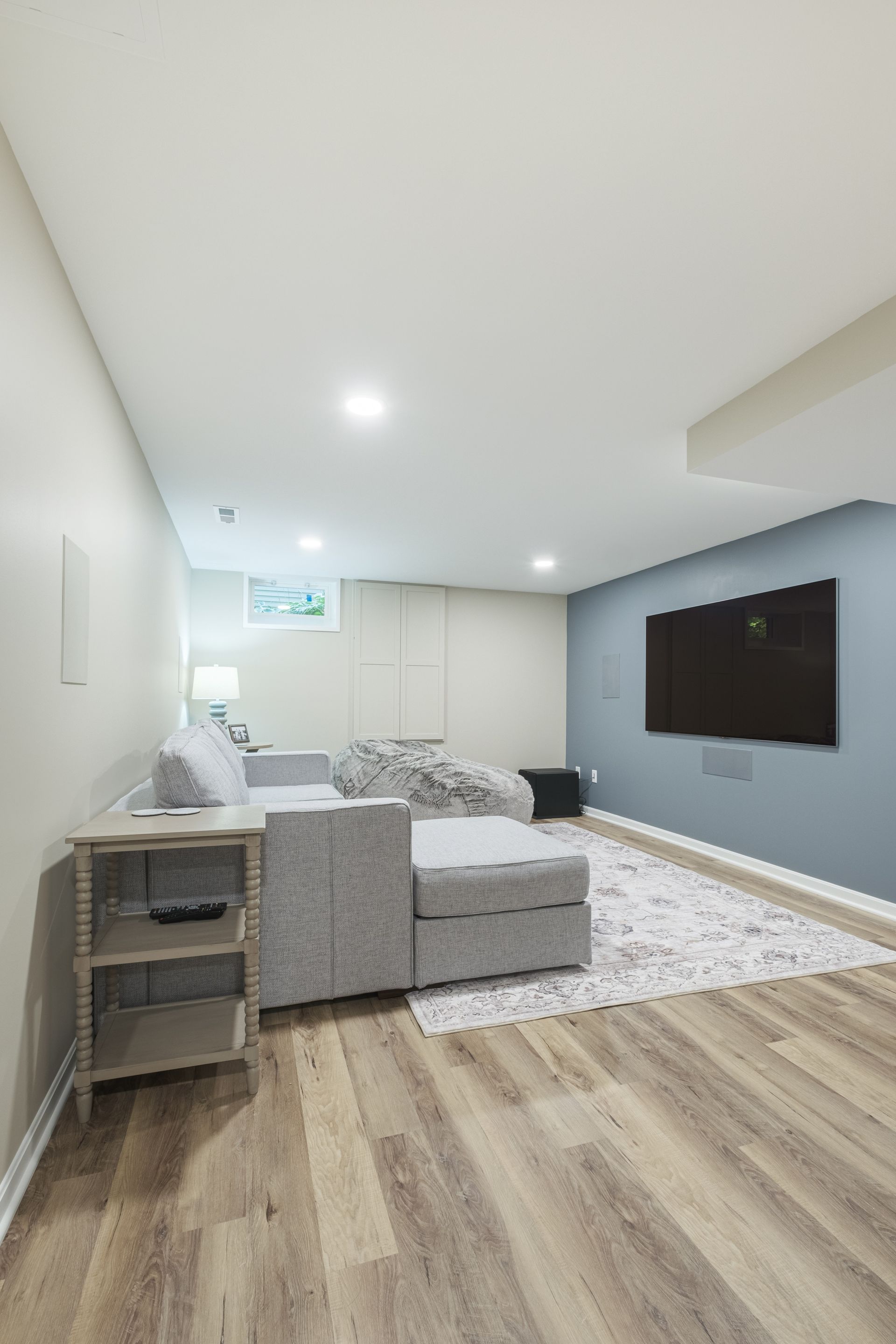 A living room with a couch and a flat screen tv on the wall.