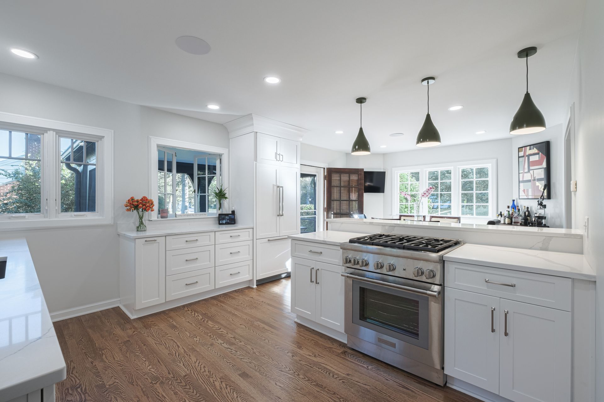 A kitchen with white cabinets , stainless steel appliances , and hardwood floors.