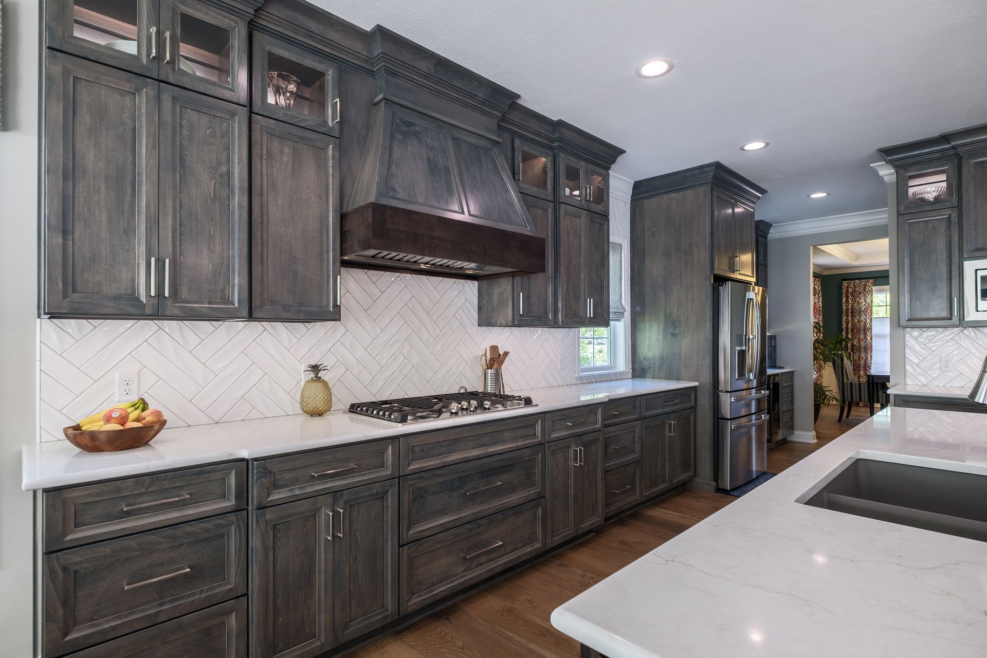 Gray kitchen with white countertops, backsplash, cabinets, and stainless steel appliances.