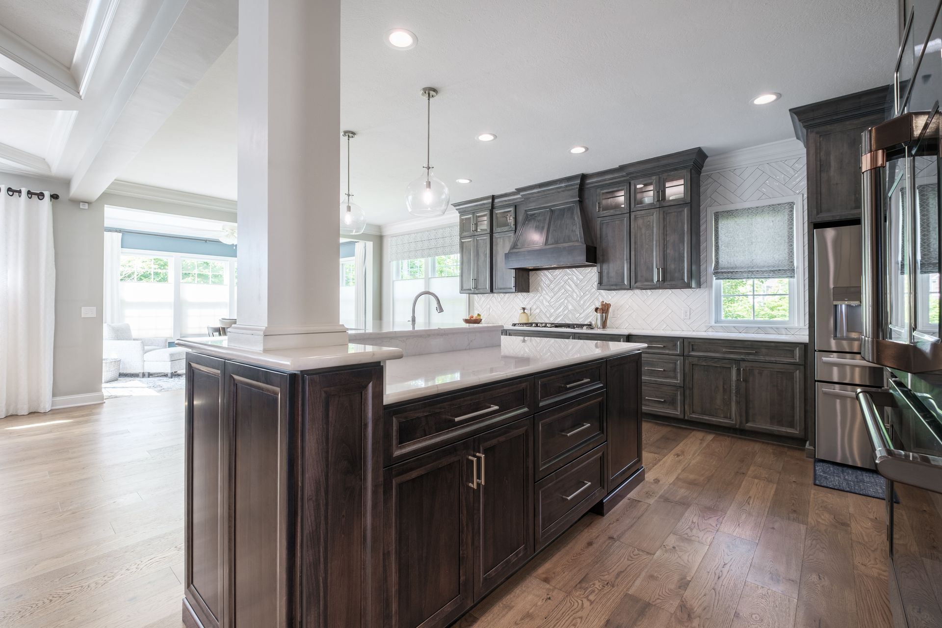 Modern kitchen with dark cabinets, large island, and light wood floors.