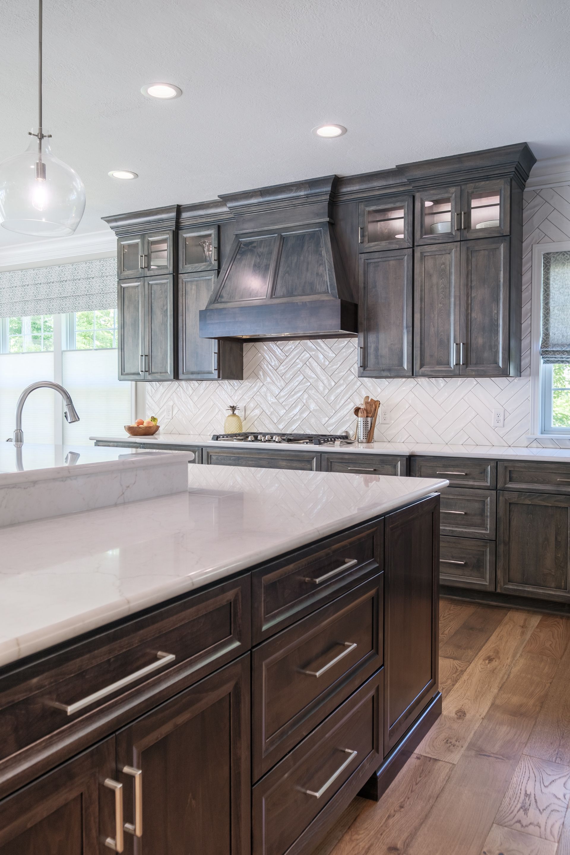 Kitchen with dark gray cabinets, white countertops, and a wooden island.