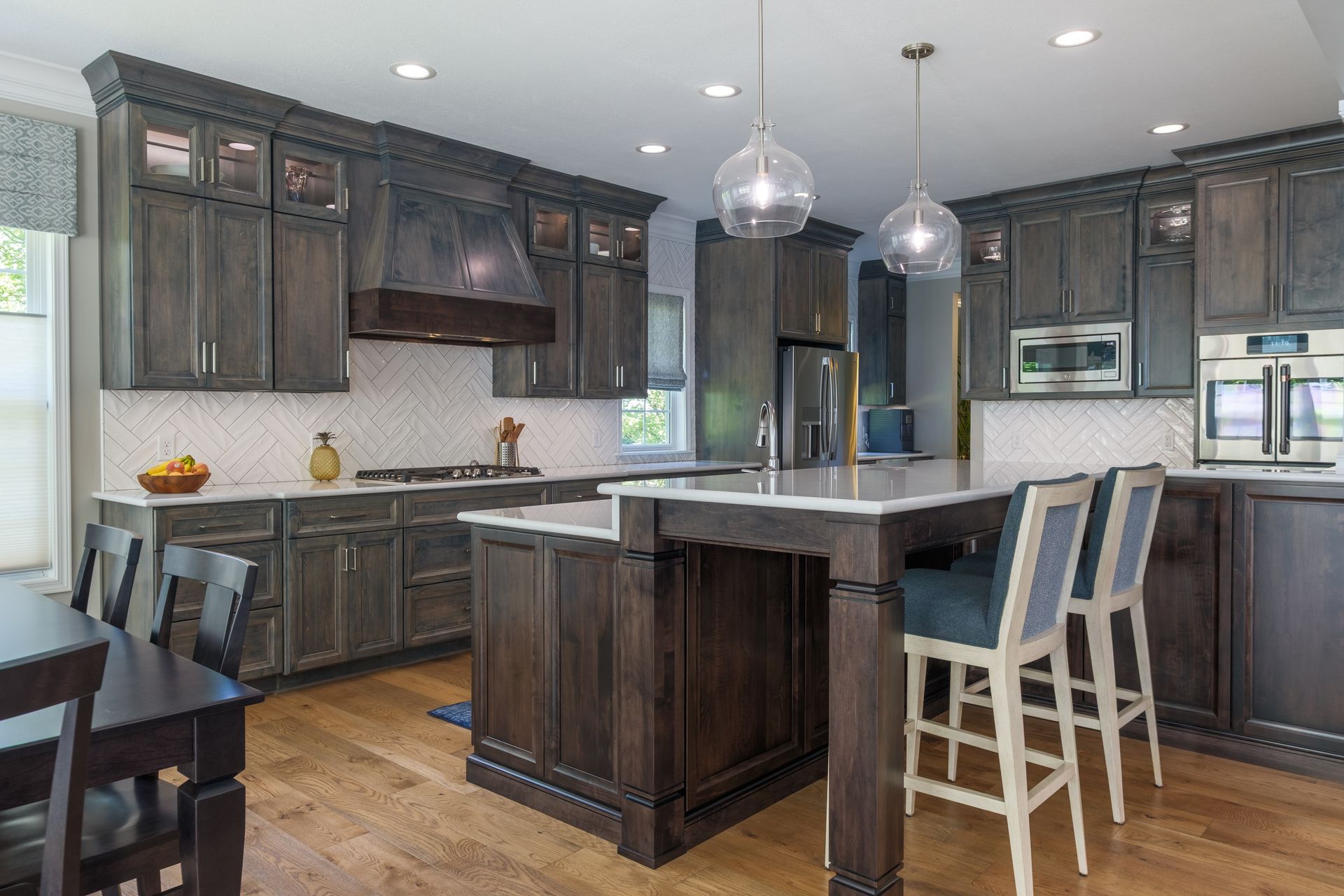Dark wood kitchen with island, pendant lights, and breakfast bar seating.
