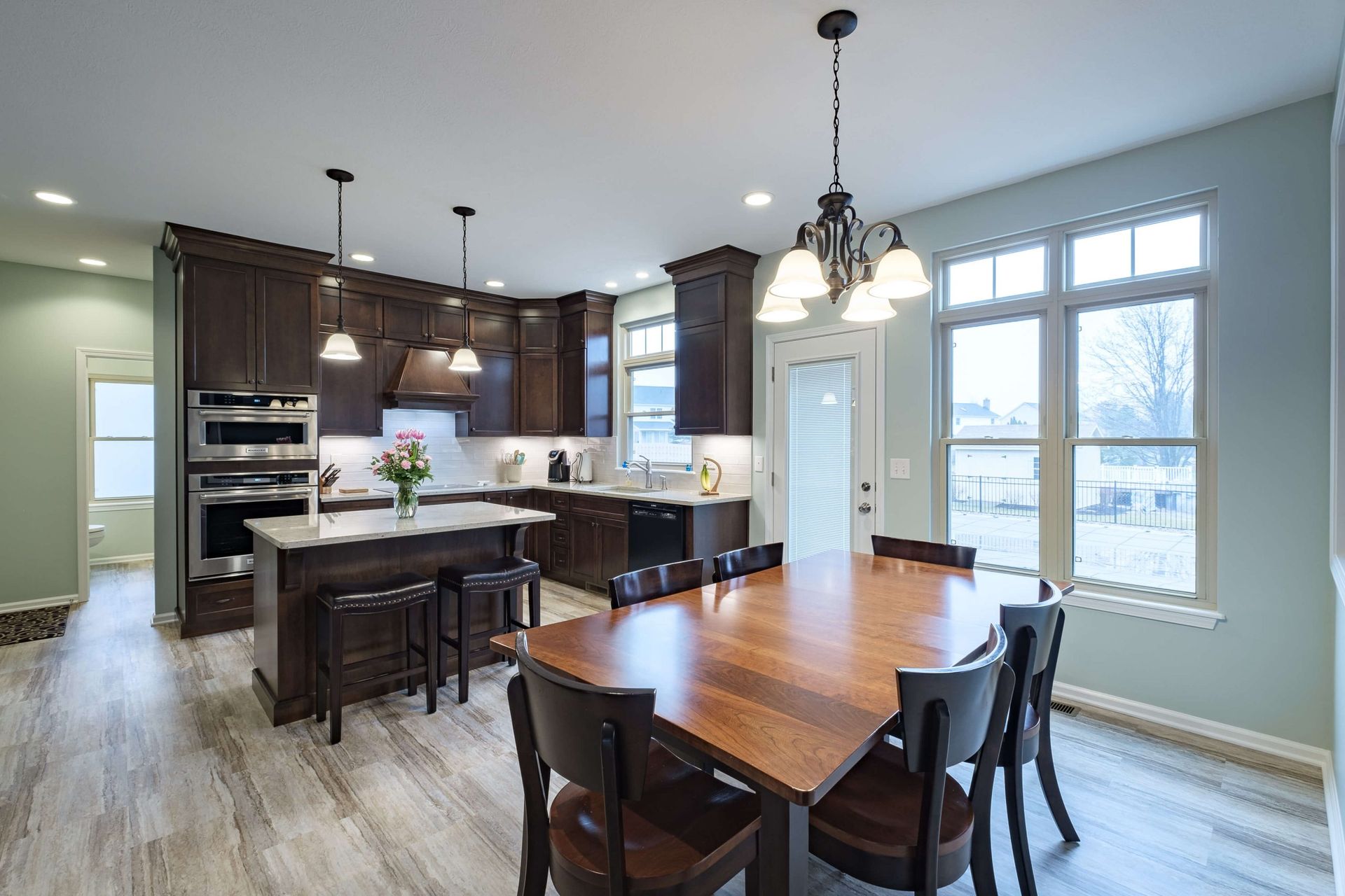 A kitchen and dining room in a house with a large wooden table and chairs.