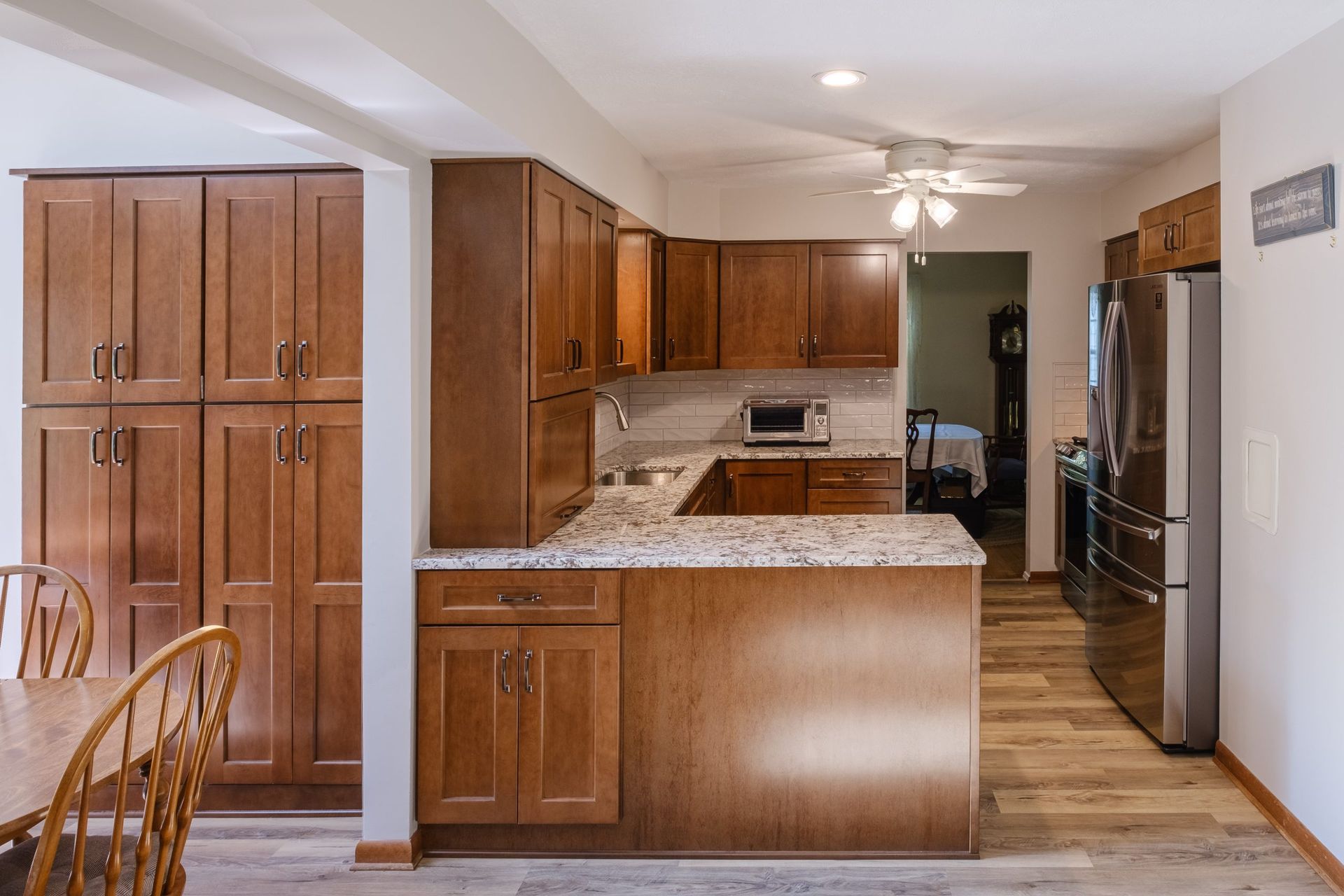 A kitchen with wooden cabinets , granite counter tops and stainless steel appliances.