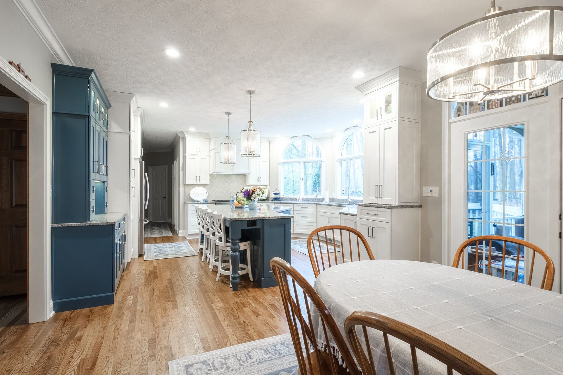 There is a table and chairs in the middle of the kitchen.