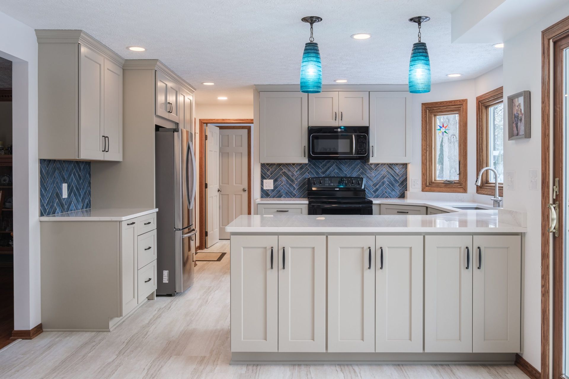 A kitchen with white cabinets , stainless steel appliances , and a large island.