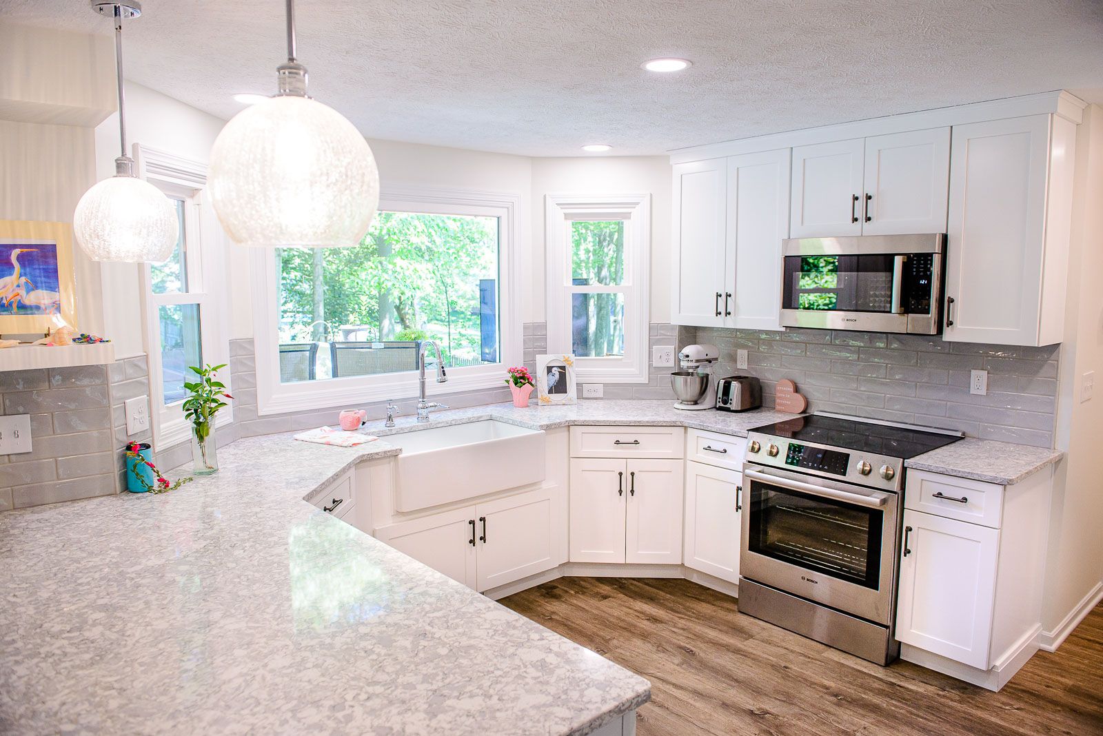 A kitchen with white cabinets , stainless steel appliances and granite counter tops.