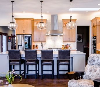 A kitchen with stools and a stove top oven