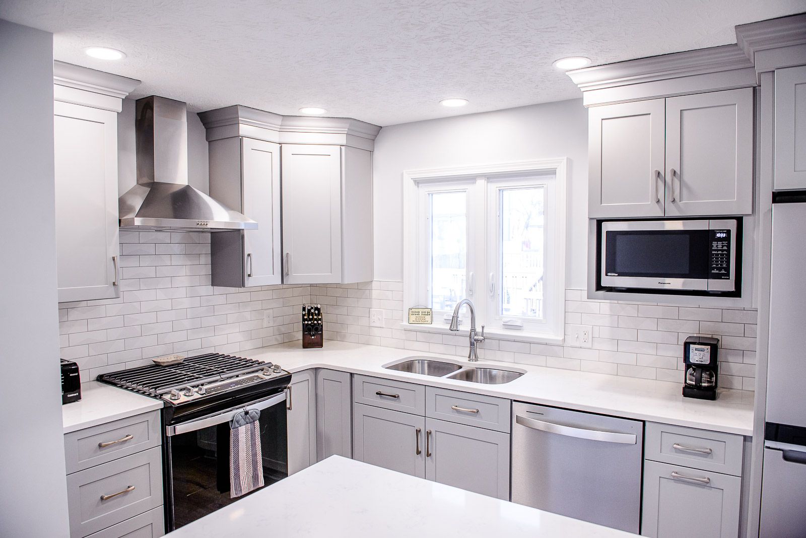 A kitchen with white cabinets and stainless steel appliances.