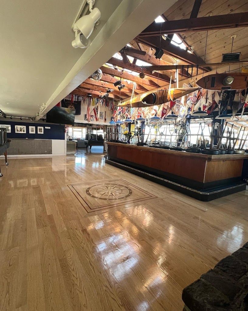 A large room with a wooden floor and a bar.
