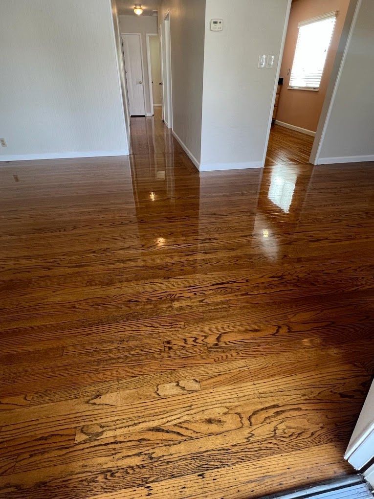 A room with hardwood floors and a hallway leading to another room.