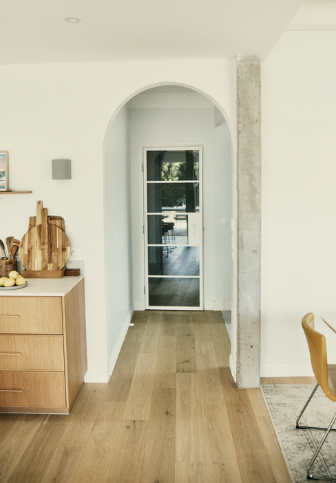 Cuisine en bois clair ouverte sur un couloir en arche, rénovation par M La Déco à Anglet