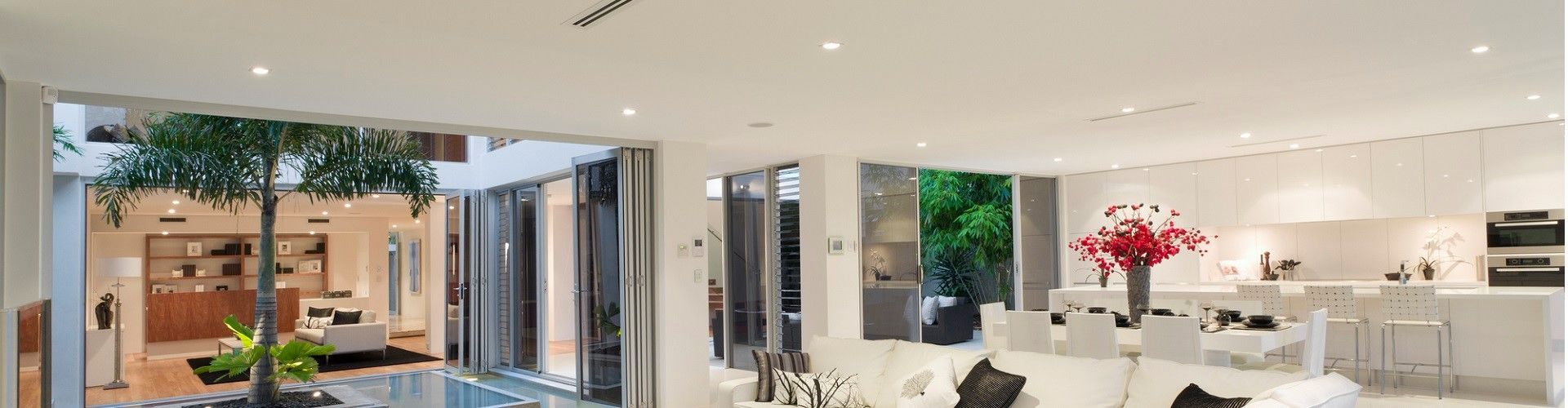 Spacious Modern Living Room With Indoor Tree, White Decor, And Outdoor Views — LSEA Electrical Group in Bucasia, QLD