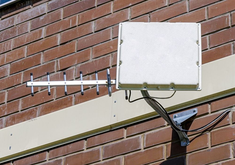 White Antenna and Rectangular Box Mounted on a Brick Wall — LSEA Electrical Group in Bucasia, QLD