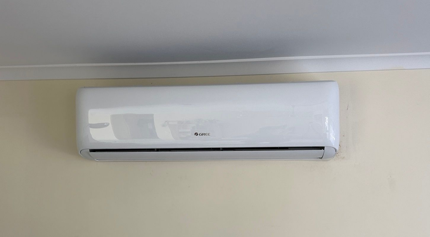 White Wall-mounted Air Conditioner on a Beige Wall, Mounted Below a White Ceiling — LSEA Electrical Group in Bucasia, QLD