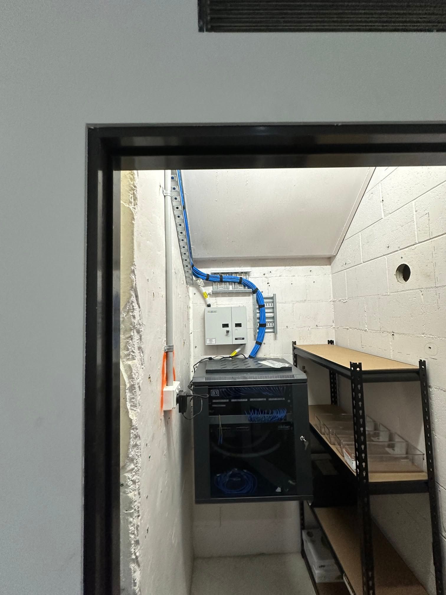 Utility Room With a Black Appliance, Shelves, and Tiled Walls — LSEA Electrical Group in Bucasia, QLD