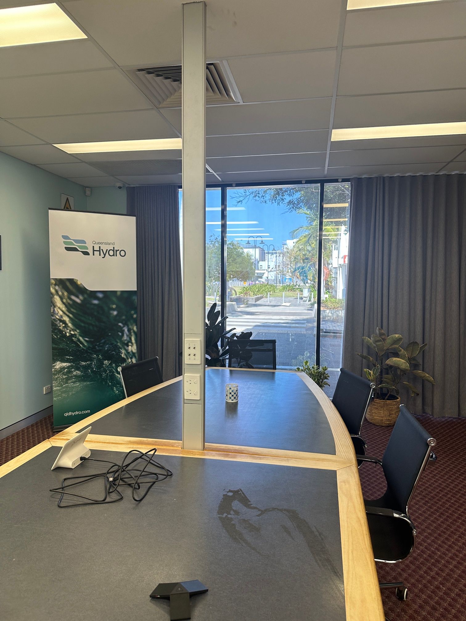 Conference Room With Long Black Table, Chairs, Windows, And A White Power Pole — LSEA Electrical Group in Bucasia, QLD