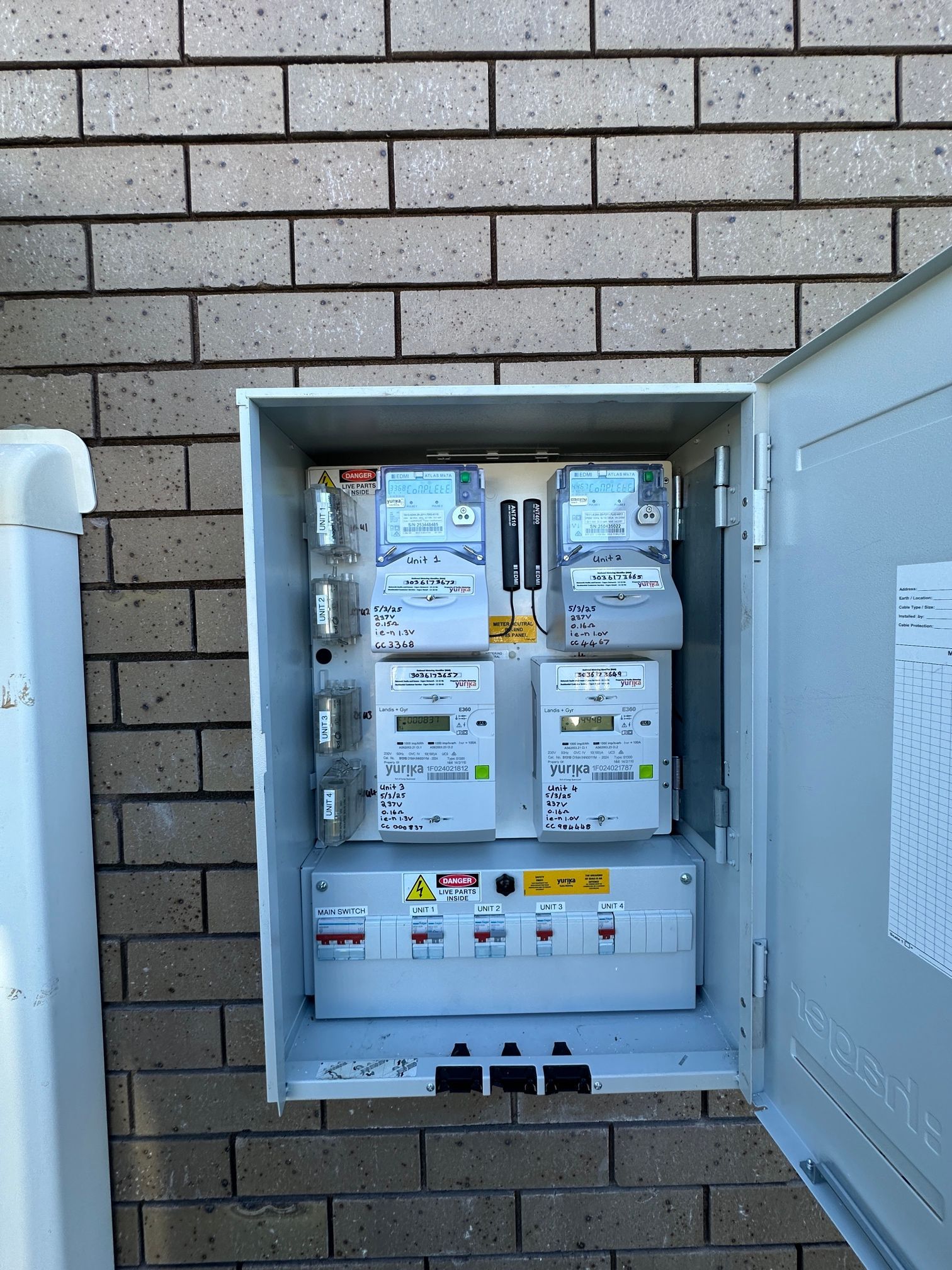 Open Gray Metal Electrical Meter Box on a Brick Wall — LSEA Electrical Group in Paget, QLD