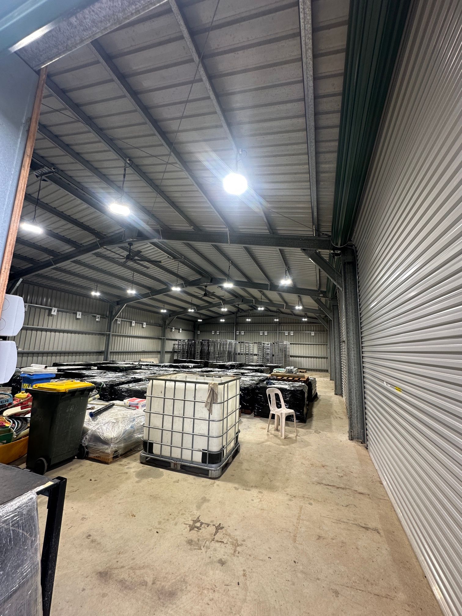 Inside a warehouse with metal roofing and walls; various items and objects are stored within — LSEA Electrical Group in Bucasia, QLD