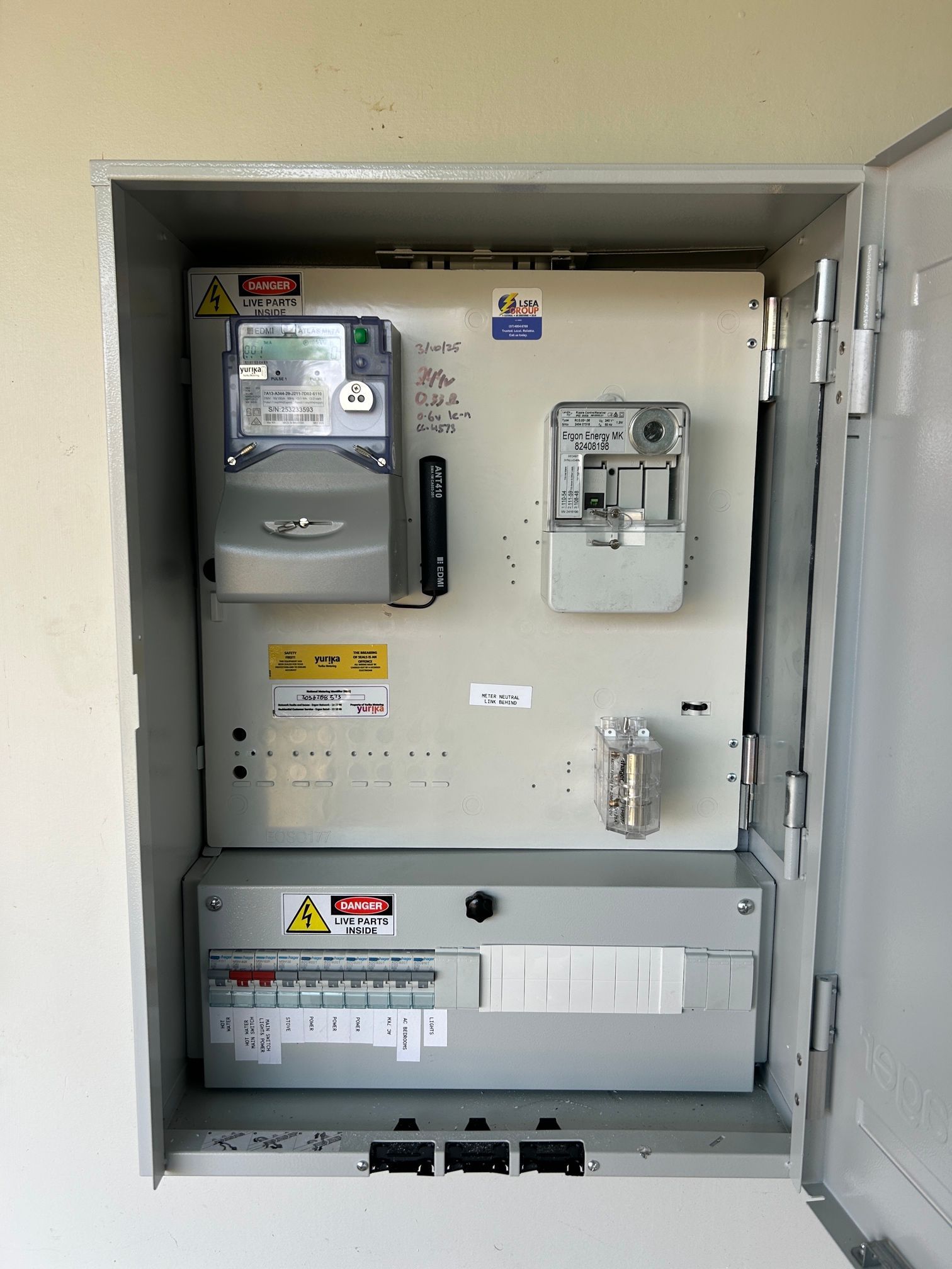 Electric Meters And Breakers Mounted In A Metal Cabinet On A Brick Wall — LSEA Electrical Group in Bucasia, QLD