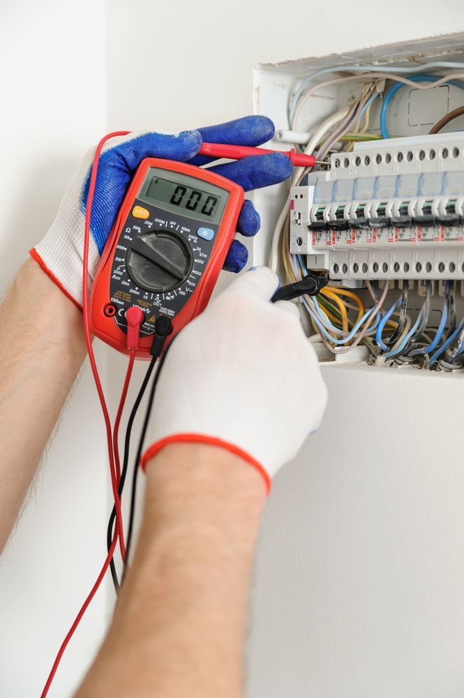 Technician Using a Digital Multimeter to Test Wiring — LSEA Electrical Group in Bucasia, QLD