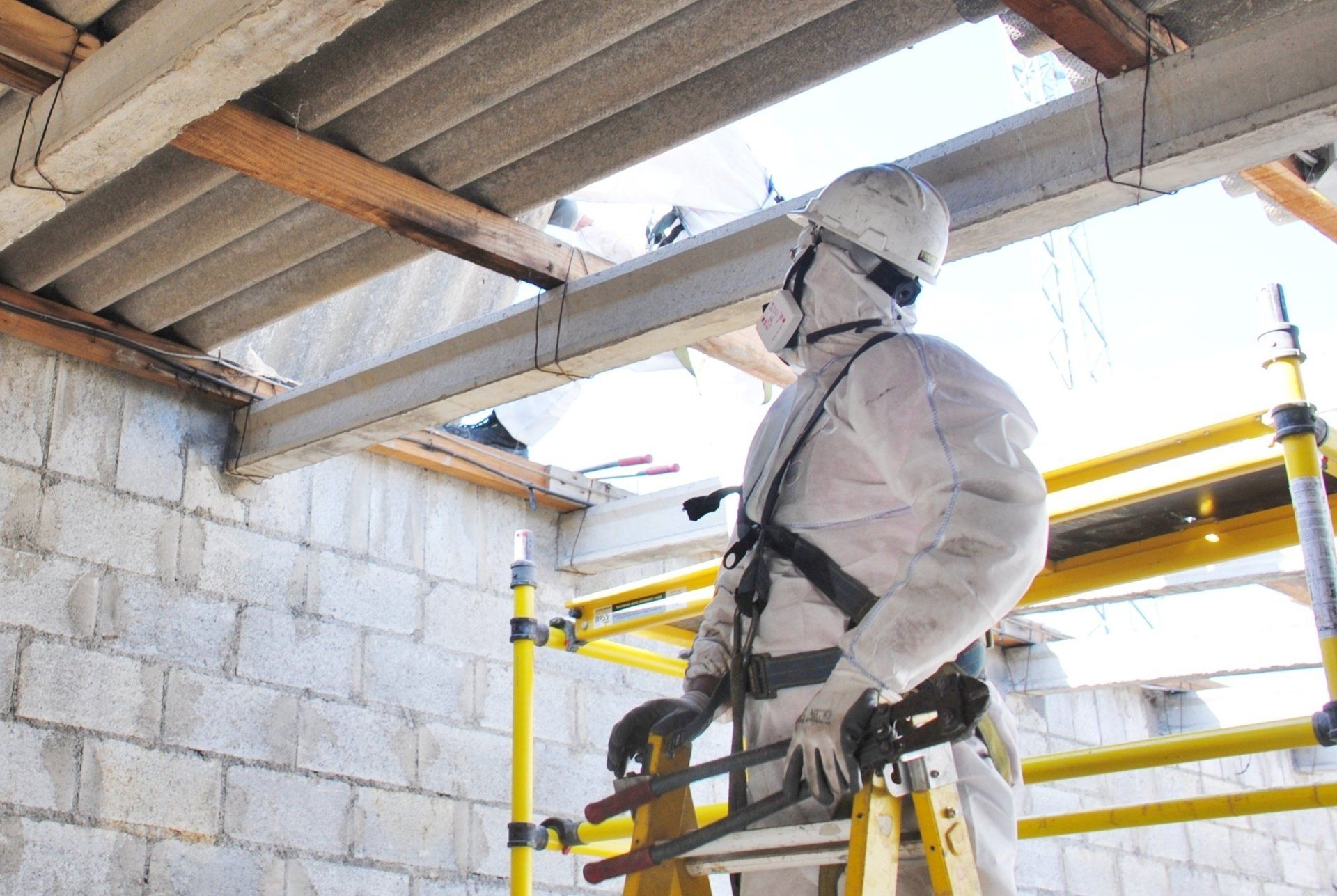 a man in a white suit is standing on a ladder