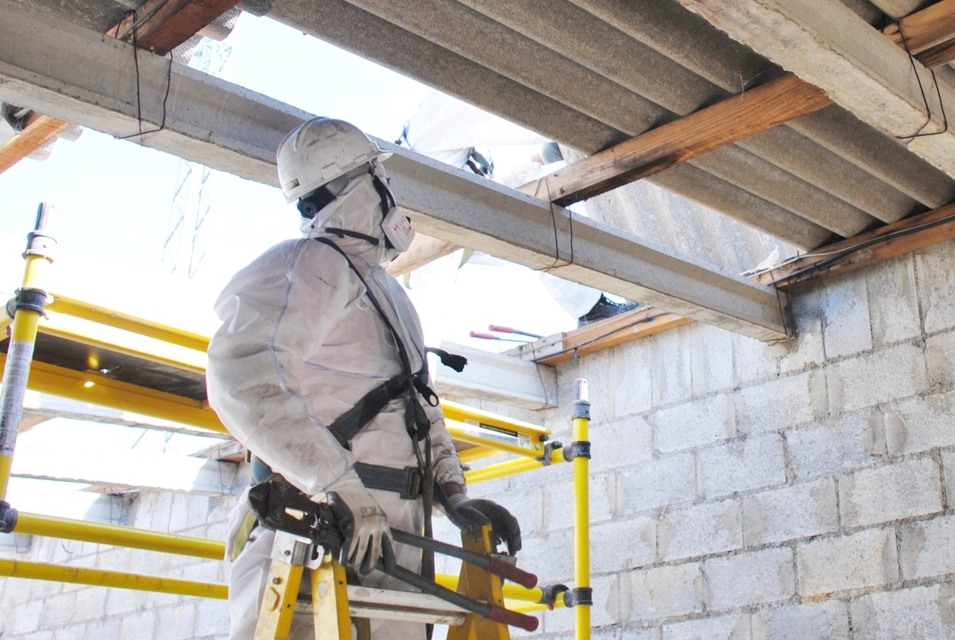 a man in a protective suit is standing on a ladder