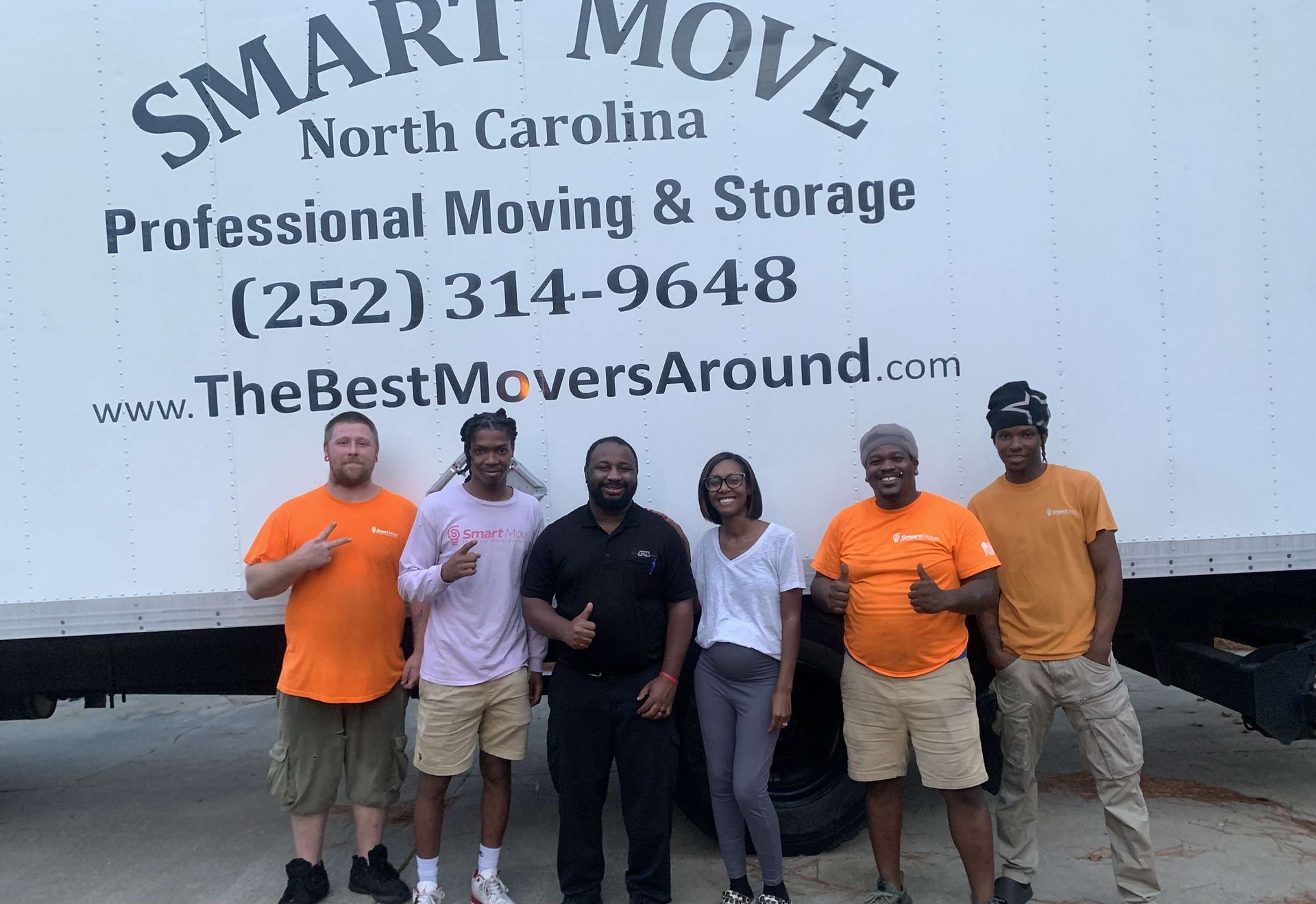 Smart Move professional moving team posing together in front of a company truck to showcase our expert moving services.