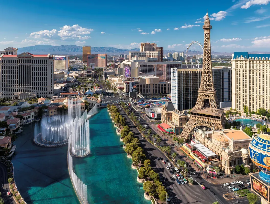 The Las Vegas Strip featuring the Bellagio fountains, Paris Hotel's Eiffel Tower replica, and surrounding resorts.