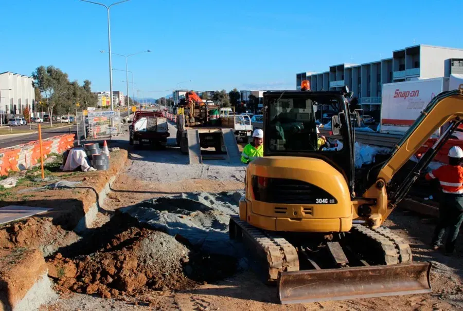 A construction site with a yellow excavator in the foreground