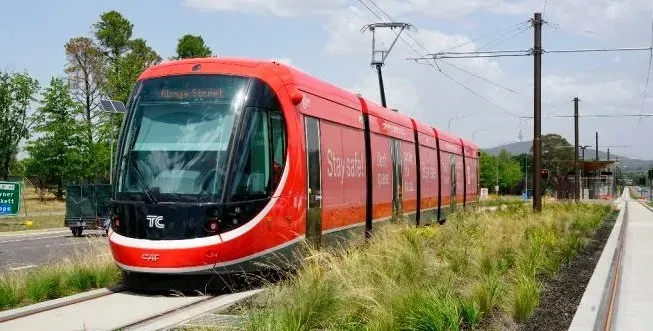 A red and black train is going down the tracks.
