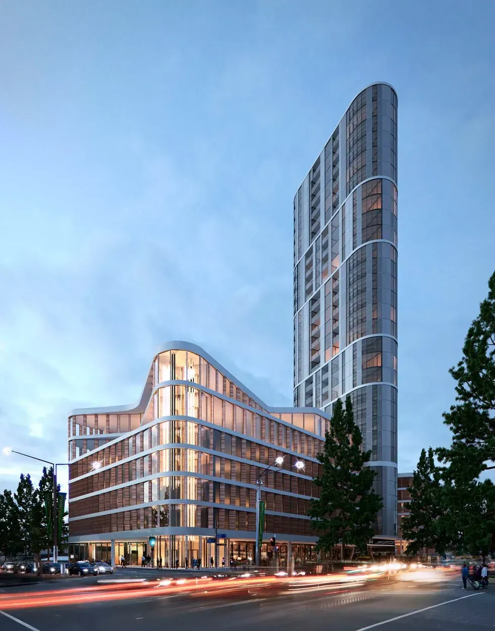 A large building with a lot of windows is sitting on the corner of a city street.