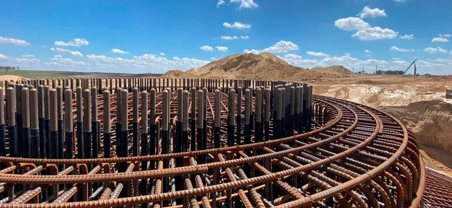 A large metal structure is being built in the middle of a desert.