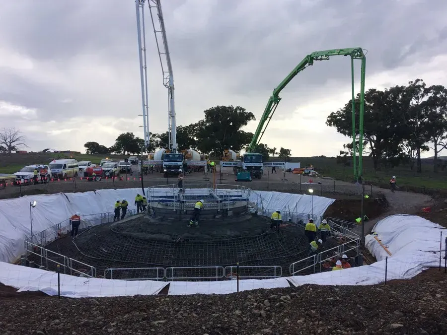 A concrete pump is being used to pour concrete into a large hole.